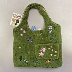 a green purse with patches and flowers on it