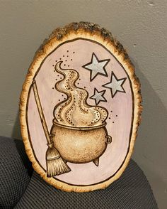 a wooden sign with a pot and broom on it's side that has stars in the background