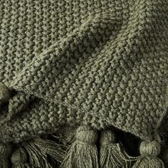 a close up view of a blanket with tassels