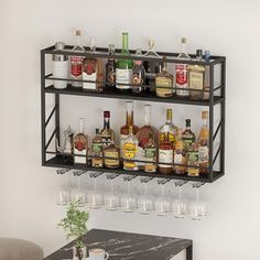 a shelf filled with liquor bottles and glasses on top of a table next to a chair