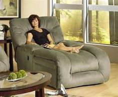 a woman sitting in a reclining chair with her feet up on the end table