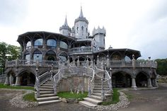 an elaborately designed house with stairs leading up to it