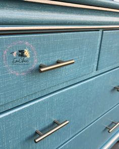 a close up of a blue dresser with metal handles