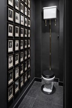 a black and white bathroom with pictures on the wall next to a toilet that is covered in photos