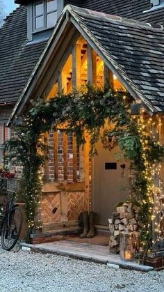 a house that has lights on the front and side of it, with a bicycle parked outside