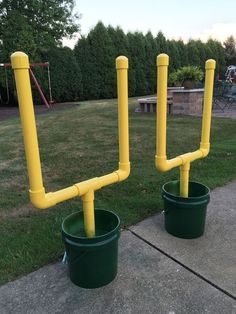 two plastic buckets with yellow handles on them