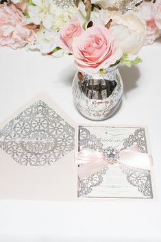 a bouquet of flowers sitting on top of a table next to a card and envelope