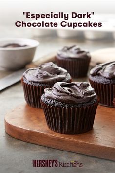 three chocolate cupcakes on a cutting board with the words, especially dark chocolate cupcakes