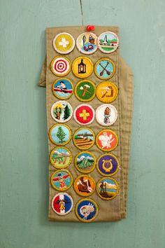 a bag hanging on the wall with many different badges