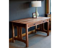 a wooden table with a lamp on top of it next to a window in a room