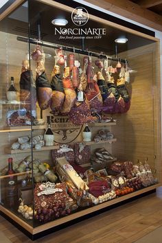 a display case filled with lots of different types of meat and cheeses on shelves