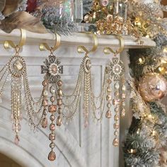 a fireplace decorated for christmas with ornaments hanging from it's mantle and tree in the background