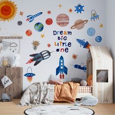 a child's bedroom with space themed wall decals and toys on the floor