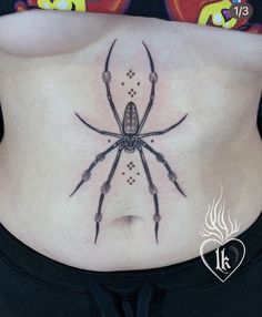 a woman's stomach with a spider tattoo on her belly and the bottom part of her abdomen