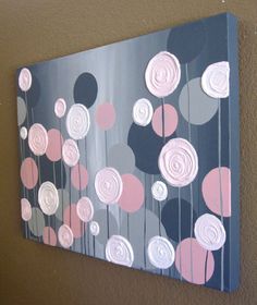 a painting with pink and gray flowers on it hanging on the side of a wall