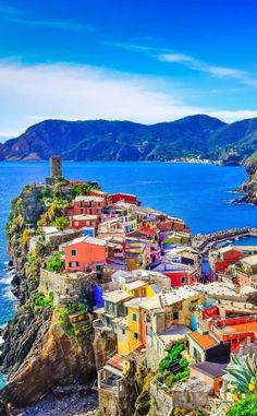 colorful houses on the edge of a cliff overlooking the ocean in cinquefoila, italy