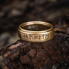 a gold ring with the word faith written on it sitting on top of a piece of wood