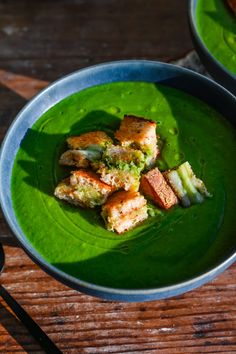 two bowls filled with food on top of a wooden table