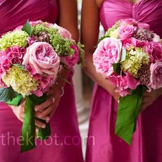 two bridesmaids in pink dresses hold their bouquets