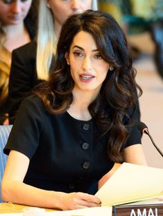 a woman sitting at a table with papers in front of her