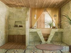 the bathroom is decorated in green and beige colors with an unusual shaped mirror on the wall