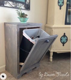 a trash can sitting inside of a wooden cabinet