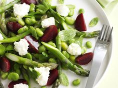 asparagus, beets and goat cheese on a white plate with a fork