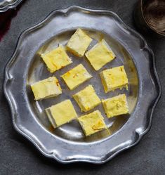 several pieces of yellow cake on a silver plate