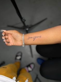 a woman's arm with the word love you written in cursive font