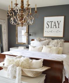 a bedroom with a bed, chandelier and pictures on the wall above it