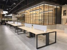 an empty room with tables and benches in it's center, surrounded by glass partitions