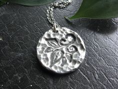 This hand-poured original pendant features a pretty leaf design. It's perfect for nature lovers, gardeners, tree huggers, or for anyone who loves the look and feel of pewter jewelry. Whether on a hike or in a business meeting, this piece looks good anywhere! This piece measures about 1-3/8" in diameter.  It's quite substantial and you can feel the weight and the quality of it when you hold it in your hand.  All of our pendants comes with a jump ring, and can be paired with one of our stainless steel chains, which we offer in two inch increments from 16 to 24 inches. Because each pendant is  finished by hand, there will be minor variations from one piece to the next. Thanks very much for stopping by our shop! Pretty Leaf, Pewter Jewelry, Jewelry Nature, Silver Leaves, Pewter Pendant, Botanical Jewelry, Tree Hugger, Leaf Jewelry, Business Meeting