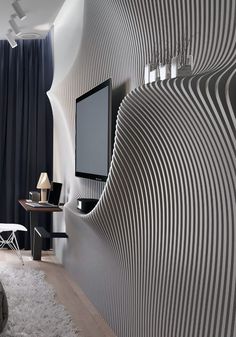 a living room with black and white striped wallpaper on the walls next to a tv