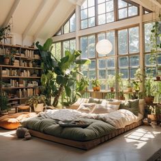 a large bed sitting in the middle of a room with lots of plants on it