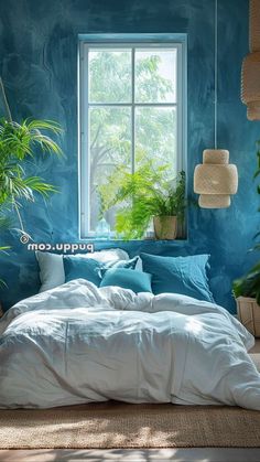 a bed in a room with blue walls and plants on the windowsill, next to a window sill