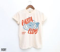 Introducing our "Pasta Club" Shirt, a stylish must-have for those who live for good food and good vibes. We use professional quality DGT printing on all our apparel. Direct-to-garment, or DTG, is a high quality printing method that sprays ink directly onto the garment so there is no peeling or cracking. This fabulous graphic will be printed on a Comfort Colors Unisex T-Shirt. Please refer to the size charts in the images for the best fit.  Estimated Production Time: 1-5 days Estimated Shipping Time: 2-5 days 100% cotton shirt  Machine wash: cold  Non-chlorine: bleach as needed Tumble dry: low heat Iron, steam or dry: medium heat Do not dry clean Food Graphic Tee, Tee Shirt Outfit Ideas, Graphic Tee Shirt Outfit, Pasta Shirt, Shirt Outfit Ideas, Tee Shirt Outfit, Food Shirt, Pasta Lover, Retro Graphic Tees