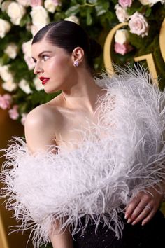 a woman in a black dress and white feather shawl