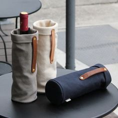 three different types of bags sitting on top of a table next to a wine bottle