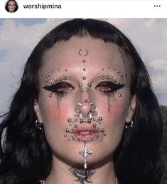 a woman with makeup and piercings on her face