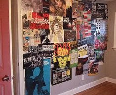 a wall covered in posters and pictures next to a red door