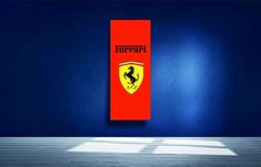 there is a red ferrari sign hanging on the wall in an empty room with blue walls