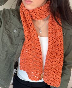 a woman wearing an orange crocheted scarf