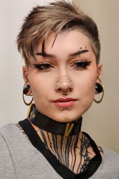 a woman with piercings on her face and nose