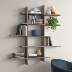 a white shelf filled with books next to a blue chair