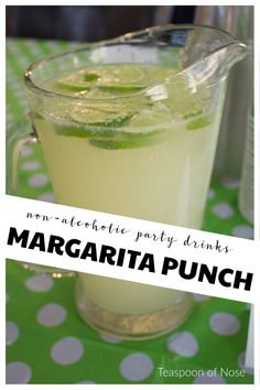 margarita punch in a pitcher with limes on the rim and polka dot tablecloth