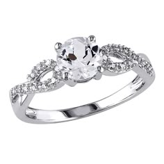 a white gold engagement ring with an oval cut center surrounded by round brilliant czrs