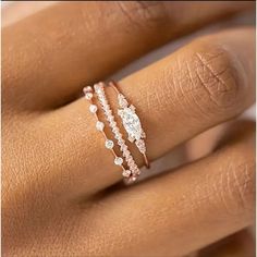 a woman's hand with three different rings on her finger and the ring has two diamonds