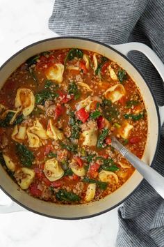 a large pot filled with tortellini soup on top of a table