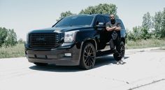 a man standing next to a black truck