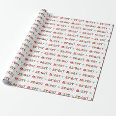 a white wrapping paper with colorful merry lettering on the front and bottom, featuring multicolored letters